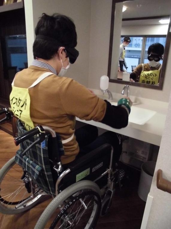 「ウエリスオリーブ町田中町」で実施された車いすで「誰でもトイレ」の体験をしているシーンの写真