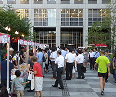 グランパーク夏祭りで人々が屋台に立ち寄っている写真