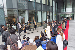 サックス奏者と、その音楽を聴いている多くの人の写真