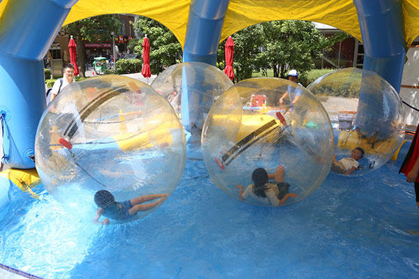 子ども達がウオーターバルーンで遊んでいるUDX夏祭りの写真