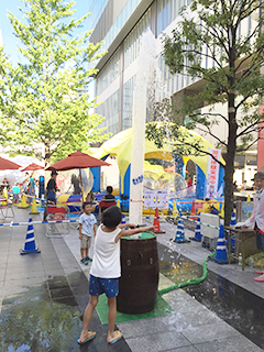 UDX夏祭りで子どもが水遊びをしている写真